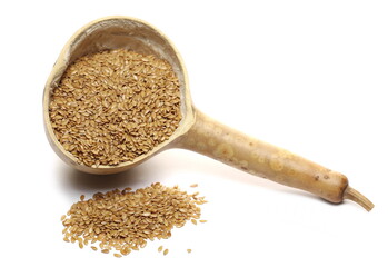 Golden linseed, linen seed pile with calabash gourd half isolated on white background