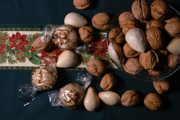 Christmas sweets with nuts and almonds over a christmas tablecloth