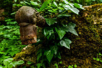 old rusty water tap from a fountain at a old castle in the forest