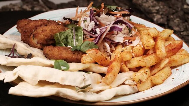 kebab, gyros, shawarma on a plate. French fries. Rotates on a plate. Cyclic motion