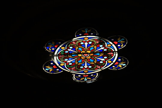 A colorful stained glass window in the dark