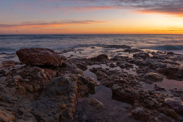 Atardecer en el mediterráneo con olas rompiendo 