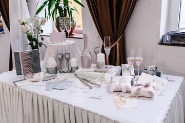 Wedding decor in style of a luxury. Decoration of a photoshoot. Details. Wedding accessories bride, invitation, box, glasses, bottles champagne, candles on the table. Preparing.