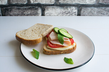 Delicious sandwich with ham, tomato, cucumber, cheese and mint.