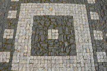 mosaic of small marble cubes. sidewalks and squares formed by stone carpet with squares, polka dots...