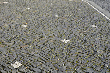 mosaic of small marble cubes. sidewalks and squares formed by stone carpet with squares, polka dots...
