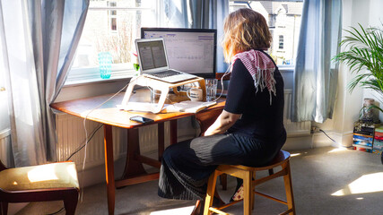 One woman working from home with an improvised desk during the emergency Coronavirus. March 2020