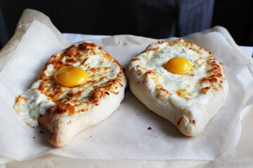 Georgian hot khachapuri on a linen napkin on the table. Family celebration.