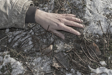 Murder. The dead man's hand lies on the melting snow.