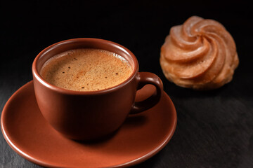 Cup of coffee with eclairs on a stone background. Top view with copy space for your text