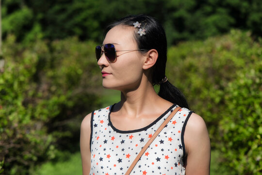 Chinese woman wearing sunglasses looking away