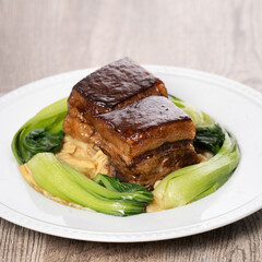 Dong Po Pork meat in a blue plate with broccoli with red background.