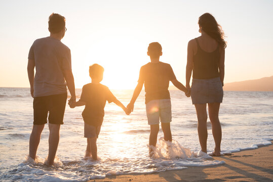 famille se tenant la main sur la plage au coucher du soleil, Nuevo Vallarta, Nayarit, Mexique
