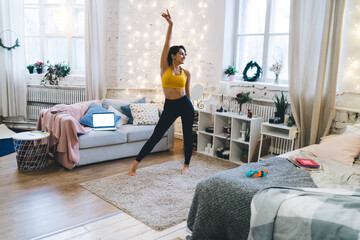 Happy Caucasian woman in sportive tracksuit dancing and rejoicing while shooting influence video...