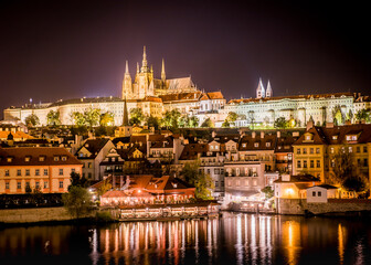 View of the city of Prague with St. Vitus Cathedral on the hill and the Vltava river at night
