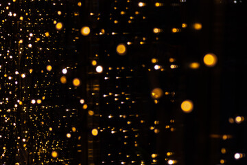 Fototapeta na wymiar Perfect bokeh for a festive New Year and Christmas background. Defocused abstract circles of yellow and blue light on windows