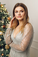 Portrait of young beautiful woman near festive Christmas Tree