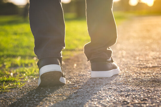 Close up of man walking outdoors in the park. Closeup on shoe, taking a step