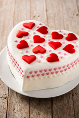 Heart cake for St. Valentine's Day, Mother's Day, or Birthday, decorated with sugar hearts on wooden table	