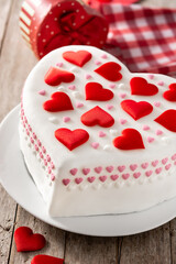 Heart cake for St. Valentine's Day, Mother's Day, or Birthday, decorated with sugar hearts on wooden table	