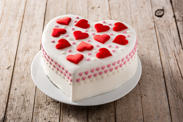 Heart cake for St. Valentine's Day, Mother's Day, or Birthday, decorated with sugar hearts on wooden table	