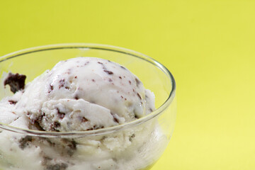 Ice cream cookies and cream in a bowl on a yellow background. Seletive focus