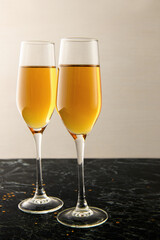 Two glasses of champagne on the black table. Alcoholic drink: champagne, beer, white wine. New year and Christmas background. Valentine's Day. Vertical photo
