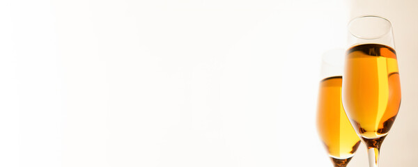 Two glasses of champagne, wine on white background. Alcoholic drink: champagne, beer, white wine. New year and Christmas background. Valentine's Day, space for text on the left. Banner.