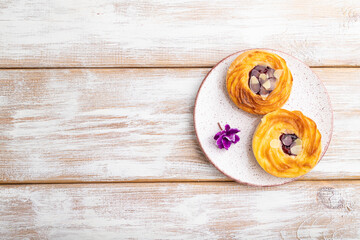 Obraz na płótnie Canvas Small cheesecakes with jam and almonds on a white wooden background. top view, copy space.