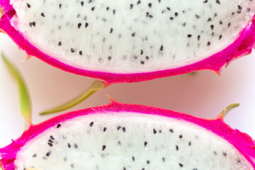 Closeup macro photo two halfs of Dragon Fruit with many black seed and pink cover