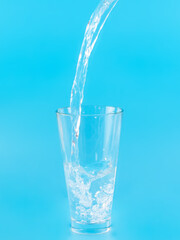 Glass with water aqua on blue background
