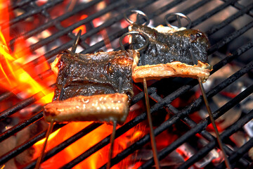 Skewered pieces of fresh Japanese marinated eel on the hot charcoal grill