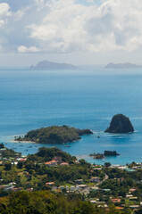 Anchoring ships in tropical bay. Yachts on blue sea water, green trees, sky and clouds. Aerial view...