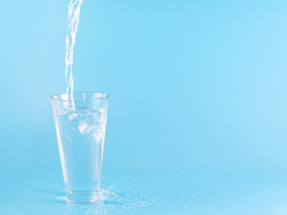 Glass with water aqua on blue background
