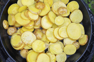 Vegan cuisine. Top view of da sliced potatoes in a pan ready for frying. Fast food concept. Ready to cook background, texture.