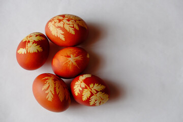 Painted Easter eggs on a white background. Floral pattern on a red eggshell. Festive food.