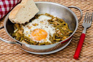 Espárragos verdes con huevo en una sartén