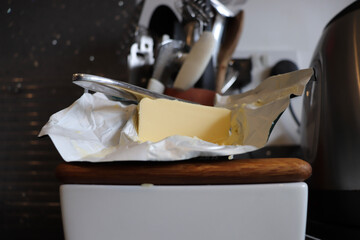 Block of butter unwrapped in the kitchen surface