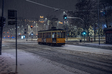 The old tram under the snow in Milan by night