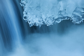 Landscape of winter waterfall framed by ice and captured with motion blur, Orangeville Creek, Michigan, USA