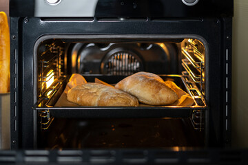 Modern and open oven with baked loaf inside
