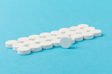Heap of pills on blue background. Medicine, pharmacy and health concept.