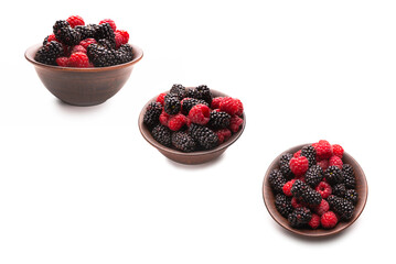 Raspberry, blackberry and mint leaf in ceramic brown bowl isolated on white