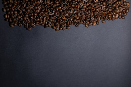 heap of coffee beans on black background. Coffee beans pile isolated on black background. Culinary coffee background. © Misha