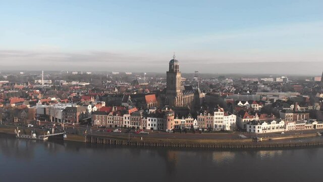 Aerial ascend showing the Dutch Hanseatic medieval city of Deventer in The Netherlands with the river IJssel at sunrise