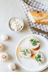 Homemade mushroom pate and sandwiches. White baguette with mushroom paste on a white plate.