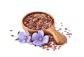 Flax seeds in wooden spoon with flowers on white background.
