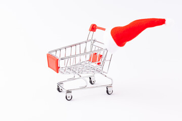 red mini trolley for supermarket with Christmas cap, isolate on a white background, used as a background or texture