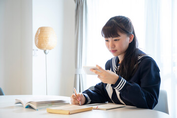リビングでオンラインん学習をする日本人女子高生