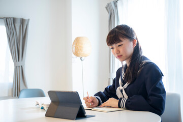 リビングでオンラインん学習をする日本人女子高生